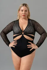 Body negro de encaje elastizado con mangas largas y transparencias. Busto forrado en LYCRA® color crudo, aro en el escote y broches en la entrepierna con fundillo de algodón.