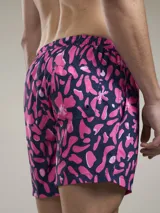 Short de baño con estampado botánico en tonos naranja y coral, con cintura elástica ajustable mediante cordón y malla interior para mayor soporte.
