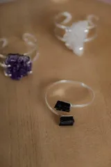 Anillo abierto de plata con diseño minimalista, decorado con una piedra natural en bruto en uno de sus extremos.