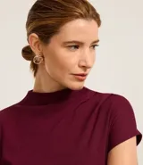 Blusa Cortelle de viscosa color bordó, con cuello alto, manga corta y textura acanalada, de diseño ajustado al cuerpo y terminación sin costuras.