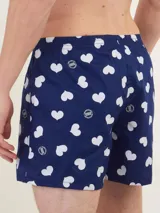 Bóxer de algodón blanco con estampado de flores pequeñas color celeste, con cintura elástica y logo de la marca en el centro.