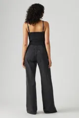 Mono largo de denim negro con corte bustier, tirantes finos y cierre frontal con cremallera.