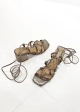 Sandalias de tacón color peltre con tiras finas y cierre con cordones.