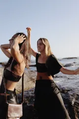 Vestido largo de dos piezas color lila con rayas verticales. El top es de corte cuadrado con mangas cortas acampanadas y elástico en la cintura. La falda es larga con volados y detalles de cuero.