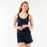 Pijama corto de dos piezas en color azul marino, compuesto por una musculosa lisa con un pequeño corazón rojo bordado en el pecho y un short con estampado de corazones blancos y elástico en la cintura.