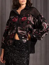 Camisa de terciopelo con diseño estampado de flores y paisley, con paneles de tela transparente en la parte superior y mangas abullonadas.