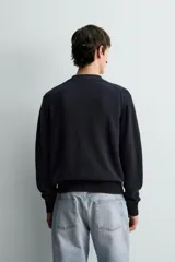 Cárdigan de punto relaxed fit confeccionado en mezcla de algodón y lino, en color azul marino. Presenta cuello en V, manga larga, bolsillos delanteros de plastrón, acabados en rib y cierre frontal con botones.