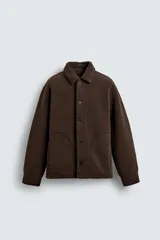 Sobrecamisa de corte relajado confeccionada en tejido con efecto borreguillo color marrón. Presenta cuello solapa, cierre frontal con botones a presión, mangas largas con puños abotonados y bolsillos frontales en la cadera.