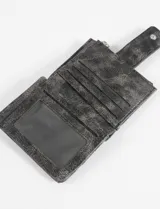 Tarjetero billetera de cuero vegano en color fucsia, con diseño acolchado y textura efecto craquelado. Cuenta con un compartimento principal con cierre metálico superior y un bolsillo frontal con solapa y broche a presión.