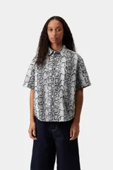 Camisa de manga corta con estampado animal print de serpiente en tonos grises y blancos, cuello camisero y cierre frontal con botones.