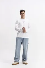 Remera de manga larga color celeste, con escote redondo y estampado frontal con la frase "FAVOR RAINS DOWN + ON ME" y el logo de Mistral.