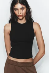 Top musculosa de punto acanalado color blanco, con cuello redondo.