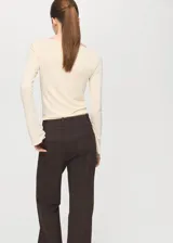 Camiseta entallada de color beige, con cuello barco y manga larga.
