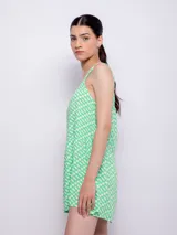 Vestido corto blanco con estampado floral en tonos naranja y lila, de corte suelto y sin mangas.