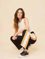 Pantalón palazzo color beige con cintura elastizada y dos franjas verticales en los laterales, una plateada y otra blanca.