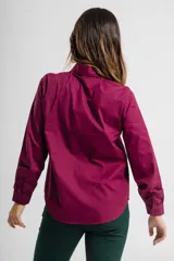 Camisa de vestir color vino, de corte clásico, con cuello camisero y mangas largas con puños abotonados.