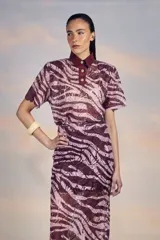 Camisa de poliéster con estampado de cebra en tonos burdeos y rosa, de corte recto con botones en la parte superior y solapa.