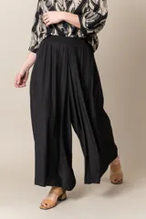 Pantalón ancho de seda color negro, con cintura elastizada y caída fluida.