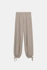 Pantalón bombacho de tiro alto, color beige topo, con cintura elástica fruncida y bajo ajustado con lazada.