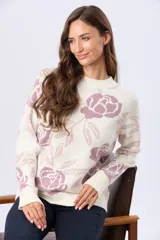 Buzo tejido en jacquard con estampado floral en tonos azul y marrón sobre base color crema. Presenta cuello redondo y puños acanalados.