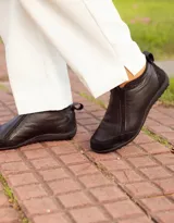 Zapatito marrón de cuero con puntera de gamuza, cierre frontal con cremallera y tirador trasero.