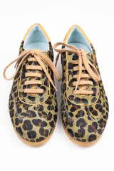 Zapatillas de estilo running con estampado animal print de leopardo. Presentan detalles en color ocre en la lengüeta, cordones, collarín y talón. Cuentan con una suela de goma dentada, entresuela blanca y una cuña interna oculta para mayor comodidad.
