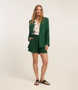 Short verde oscuro de viscolino, con pliegues delanteros, cintura con trabillas y cinturón de cuerda con hebilla metalizada.