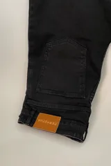 Jean negro de corte wide leg con tajo frontal y tiro medio alto.