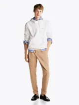 Buzo blanco de Tommy Hilfiger con capucha, cordones ajustables, logo bordado en el pecho, bolsillo tipo canguro, puños y bajo acanalados. Confeccionado en mezcla de algodón y poliéster.