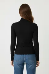 Polera blanca de algodón y elastano, corte ajustado y cuello alto.