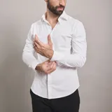 Camisa de vestir negra de manga larga, confeccionada en tejido técnico elástico y libre de arrugas, con cuello clásico y cierre frontal de botones.