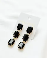 Aros colgantes con tres gemas rectangulares facetadas de color negro, engarzadas en metal dorado.