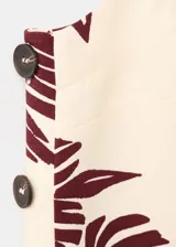 Top de tirantes finos con escote cuadrado, de corte recto y estampado floral en tonos bordó sobre base beige.
