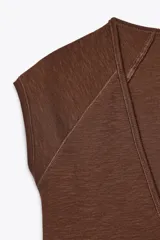 Camiseta color crudo de corte slim fit, con escote en pico, manga corta y tejido de punto acanalado.