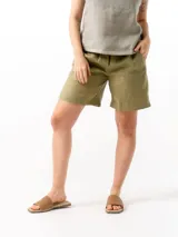 Short de lino con cintura elástica y cordón ajustable. Cuenta con dos bolsillos laterales y un bolsillo trasero, ofreciendo un ajuste cómodo y versátil.