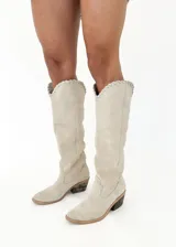 Bota tejana de cuero color beige, con caña alta y detalle de tiento cosido a mano en la parte superior. Tiene taco de 4 cm.