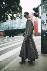 Falda midi de tiro alto ZARA Woman Collection, con diseño evasé y estampado de cuadros en tonos oscuros con líneas rojas y blancas. Cuenta con cierre lateral con cremallera oculta.
