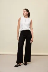 Jean wide leg negro de tiro medio confeccionado en denim con spandex, con bolsillos frontales tipo parche y silueta amplia de corte recto.