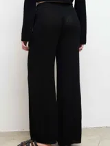 Pantalón de punto color negro, de corte recto y tiro medio, con cintura elástica y diseño de pierna ancha.