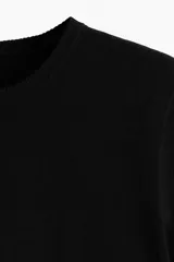 Remera corta de punto fino color negro, con cuello redondo y mangas cortas.