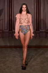 Blusa de encaje color amarillo con cuello alto, mangas largas abullonadas y detalles de volados en los hombros.