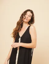 Vestido largo blanco de lino con escote en V y flecos de algodón en los bordes.