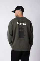 Buzo de cuello redondo en algodón rústico con efecto de lavado gastado, corte oversize y estampa frontal pequeña con texto.