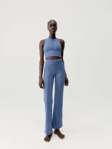 Legging flare largo de color negro, confeccionado en tejido Skin_Move. Presenta cinturilla ancha de doble tejido y un panel decorativo de malla transpirable en el centro del torso.