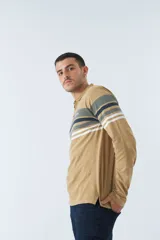 Remera tipo polo de manga larga azul marino con rayas horizontales blancas, grises y rosadas en el pecho. Tiene cuello clásico con botones y logo estampado en el pecho. Corte regular.