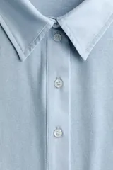 Remera polo de manga larga en punto de algodón, con cuello clásico, tapeta con botones y costuras moldeadoras en el frente.
