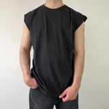 Musculosa negra de corte oversize, con hombros caídos y diseño liso.
