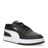 Championes Puma modelo Caven 2.0, de diseño urbano y deportivo. Presentan una base de cuero sintético en color negro con la clásica franja lateral de Puma en color blanco y detalles de la marca en dorado. Cuentan con perforaciones en la puntera para mayor ventilación y una suela de goma blanca que aporta contraste y estilo.