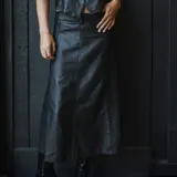 Falda larga de cuero ovino color negro, de corte recto y tiro alto.