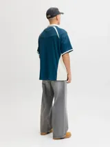 Camiseta tipo polo de manga corta con calce holgado, confeccionada en tejido técnico. Presenta cuello camisero en color blanco, detalles en contraste en hombros y mangas, y estampados gráficos en el frente con el logo de la marca y la inscripción golden hill.
